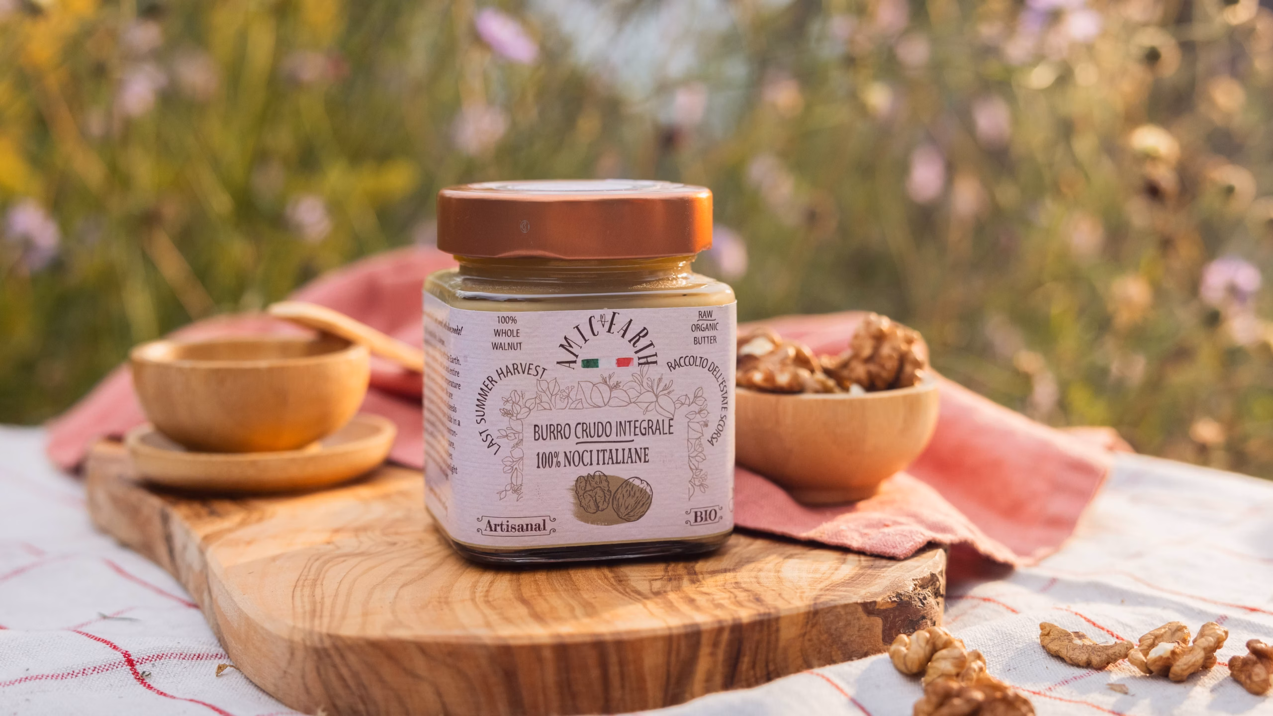 Burro crudo di noci italiane su tagliere naturale con gusci e gherigli | Raw walnut butter on rustic board with shells and kernels